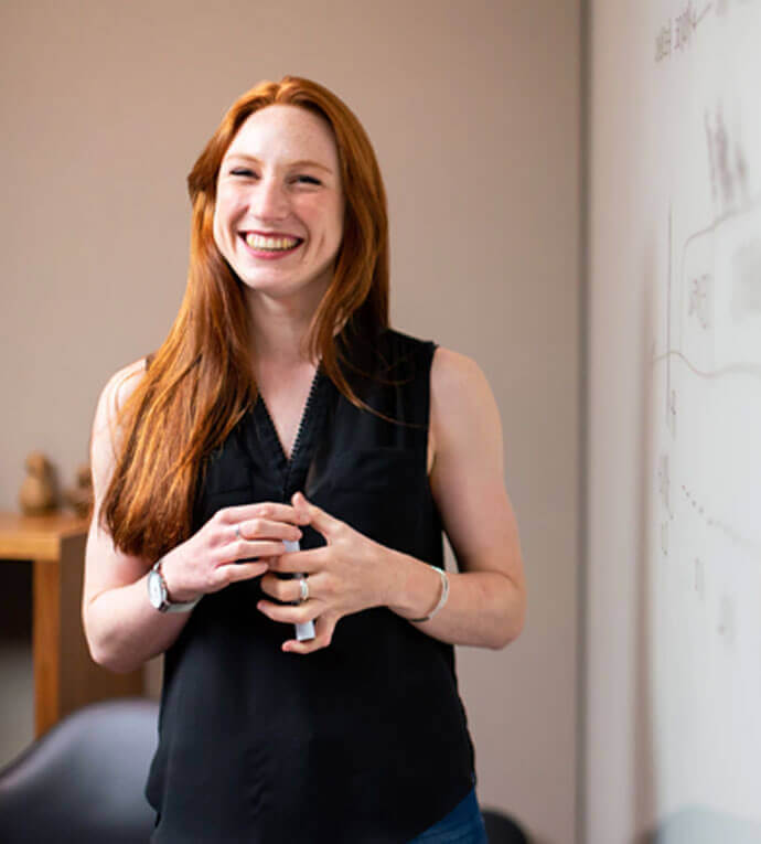 Smiling woman with red hair giving presentation.