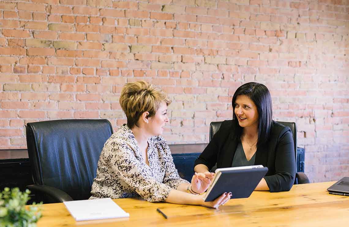 Two women discussing work in an office.