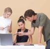 Three people working together on a laptop.