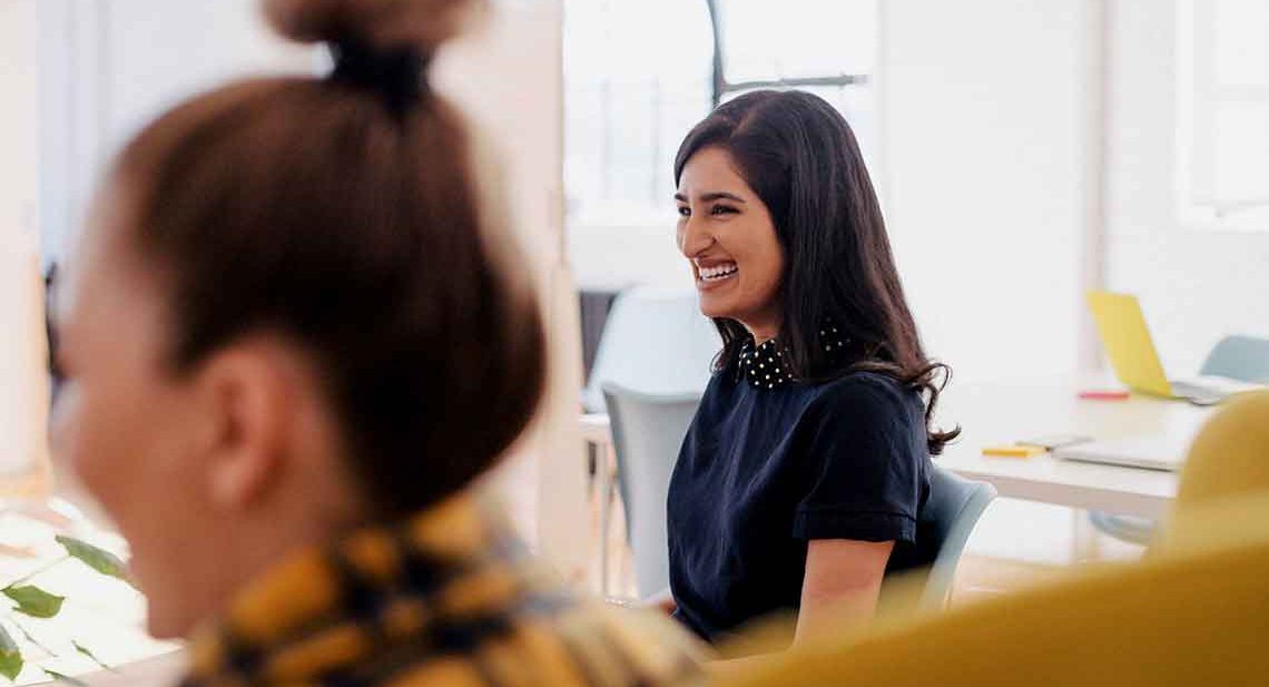 Smiling woman sitting in a chair.