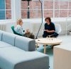 Two women talking in a modern office.