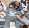 Business meeting around a table with charts.