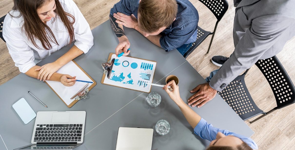 Business meeting around a table with charts.