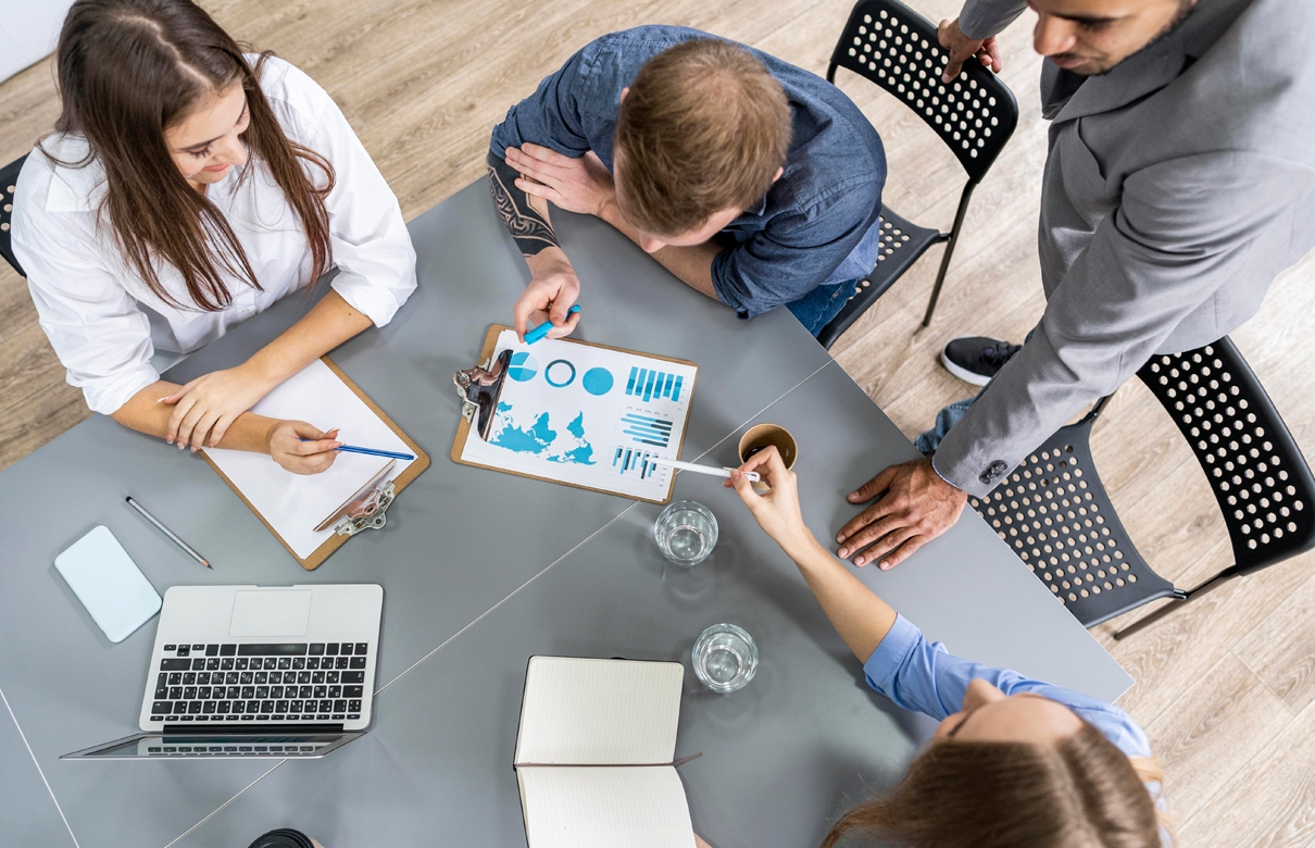 Business meeting around a table with charts.