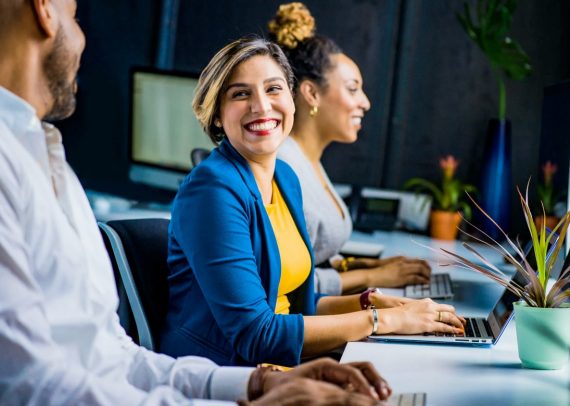 Smiling woman working at a desk with laptop.