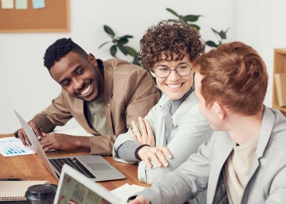 Three colleagues smiling and working together.