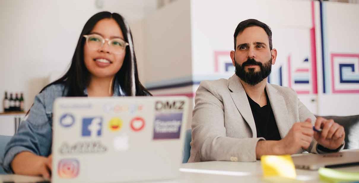 Two colleagues working at a desk.