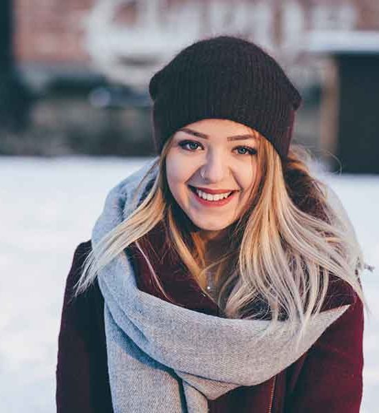 Smiling woman in a winter hat and scarf.