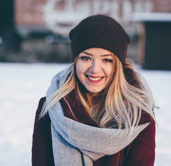 Smiling woman in a winter hat and scarf.