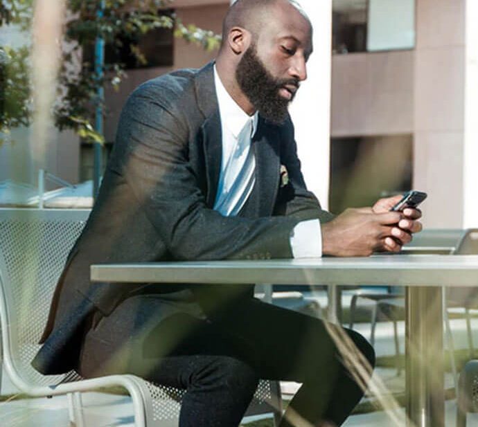 Man in suit using phone at a table.