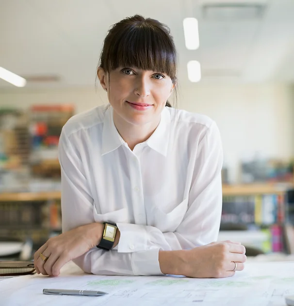 Smiling woman in white shirt, looking at camera.