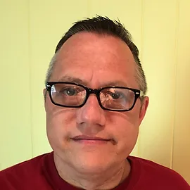 A man with glasses and a red shirt.