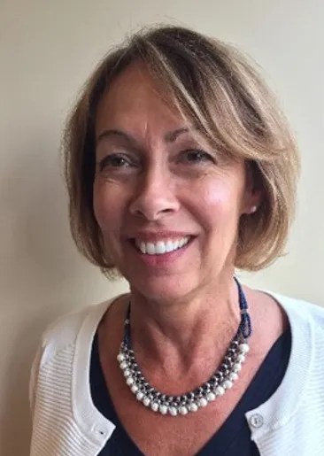 Woman smiling with white pearl necklace.