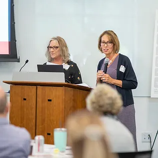 Two women speaking at a conference.