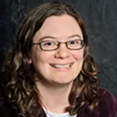 Headshot of a woman smiling and wearing glasses.